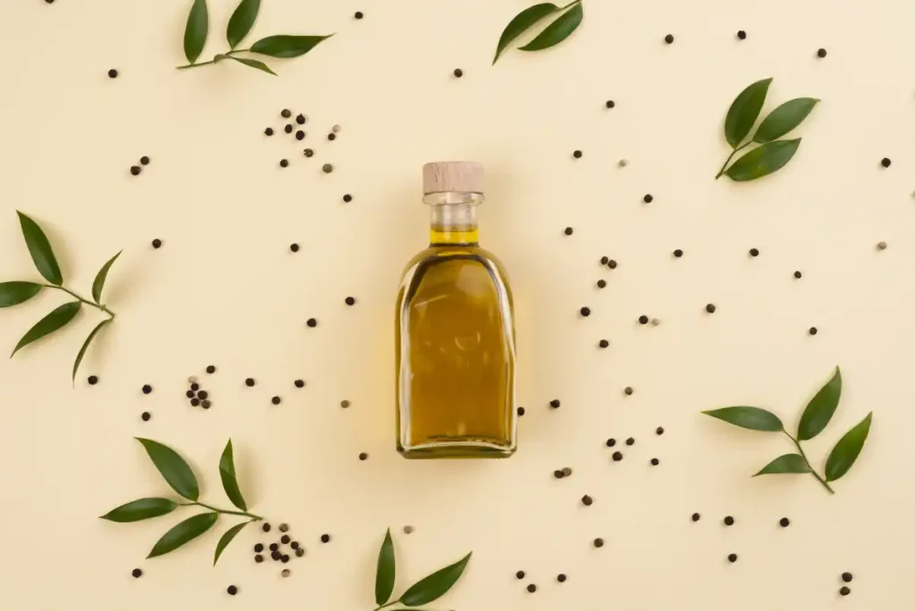 olive oil bottle surrounded by olive leaves